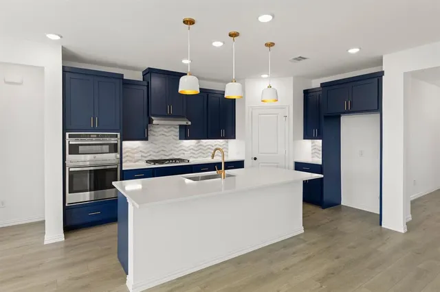 a large kitchen with stainless steel appliances kitchen island a large counter top and a stove