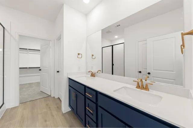 a bathroom with a sink double vanity granite tub and a mirror