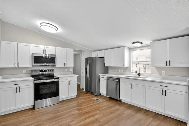 a kitchen with stainless steel appliances granite countertop a stove and white cabinets