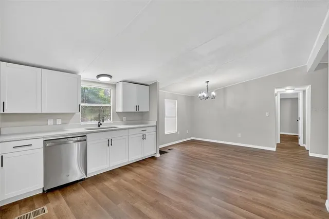a view of a kitchen with sink and wooden floor