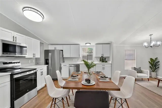 a kitchen with stainless steel appliances kitchen island granite countertop a dining table and chairs