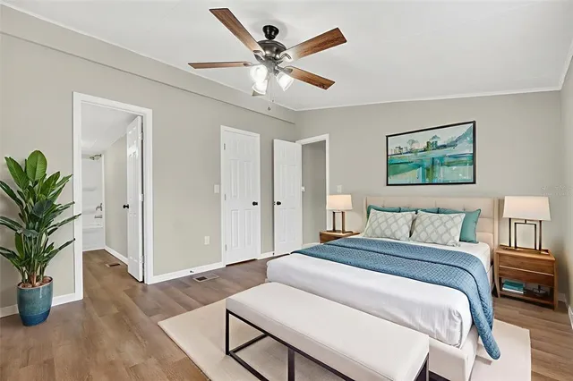 a spacious bedroom that has a bed and a potted plant