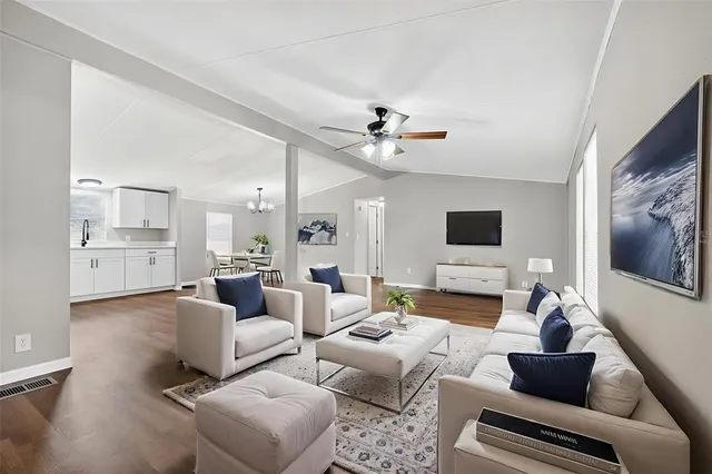 a living room with furniture ceiling fan and a flat screen tv