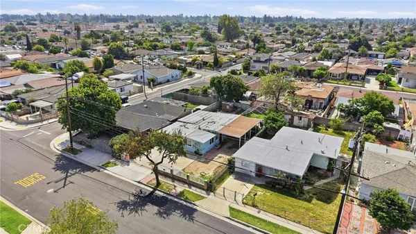 an aerial view of a residential houses with outdoor space and parking