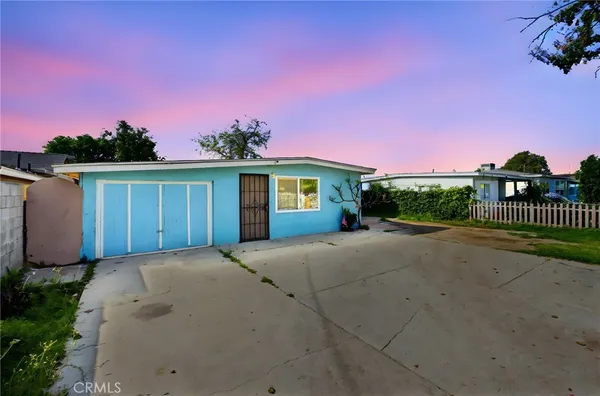 a view of a house with a yard and potted plants