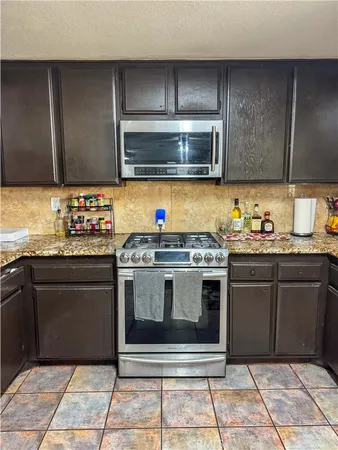 a kitchen with stainless steel appliances granite countertop a stove and a microwave