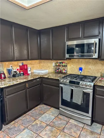 a kitchen with granite countertop stainless steel appliances and wooden cabinets