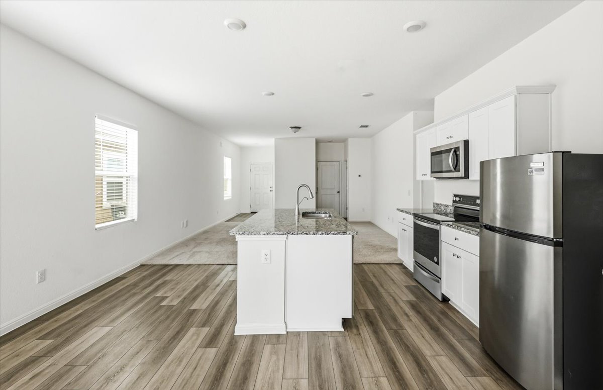 202 Peridot Pass Maxwell, TX 78656 - Photo 10 of 21 A contemporary kitchen island and stainless steel appliances anchor this inviting open-concept living space.