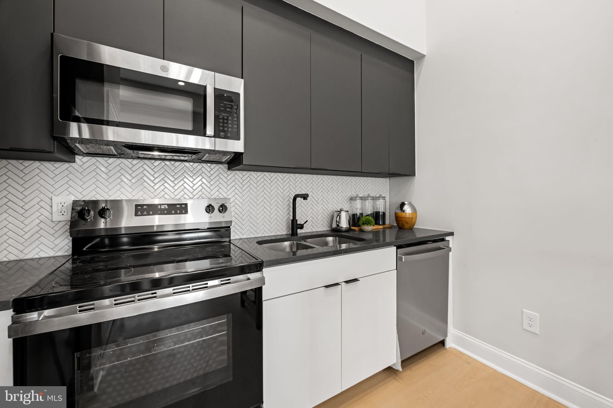 600 North Howard Street, Unit 101 Baltimore, MD 21201 - Photo 11 of 36 a kitchen with stainless steel appliances a stove a microwave sink and cabinets