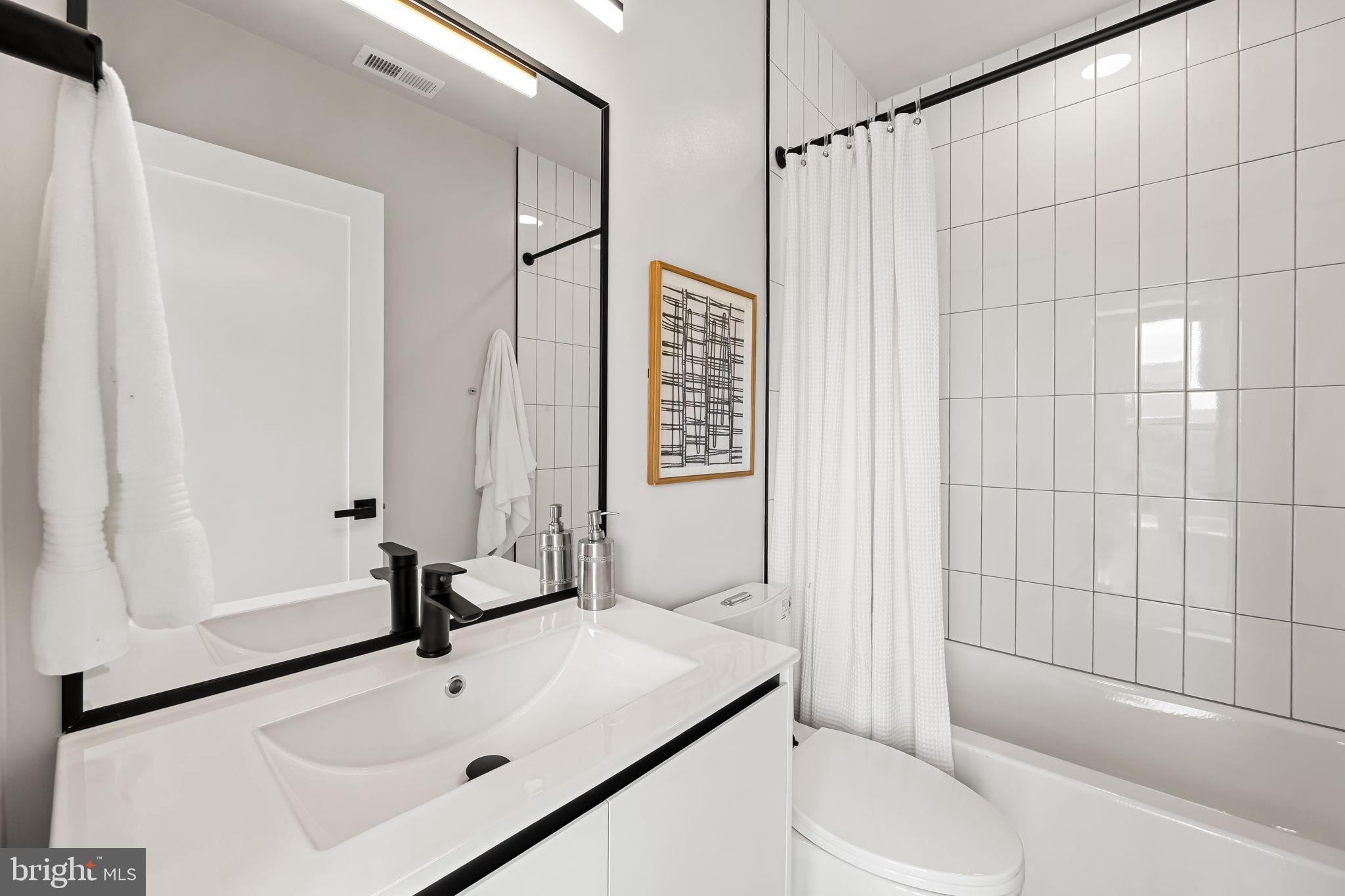 600 North Howard Street, Unit 101 Baltimore, MD 21201 - Photo 17 of 20 a bathroom with a sink toilet and shower