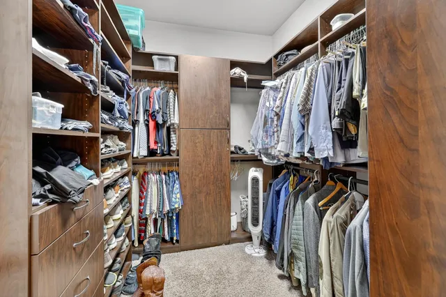 a view of walk in closet with clothes and shoes