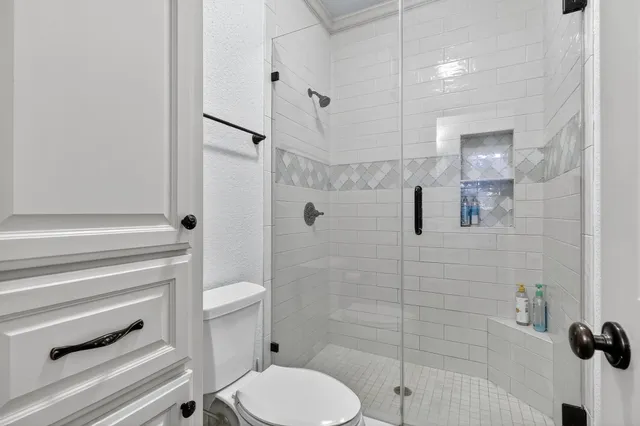 a bathroom with a toilet and a shower