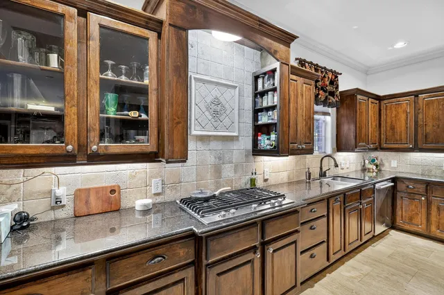 a kitchen with stainless steel appliances granite countertop a sink stove and cabinets