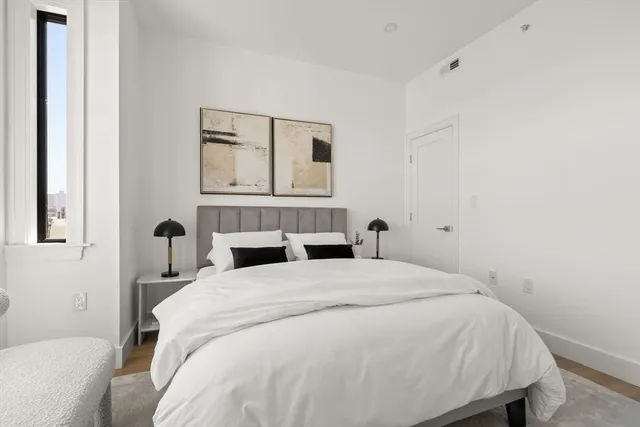 a bedroom with a bed potted plant and a window