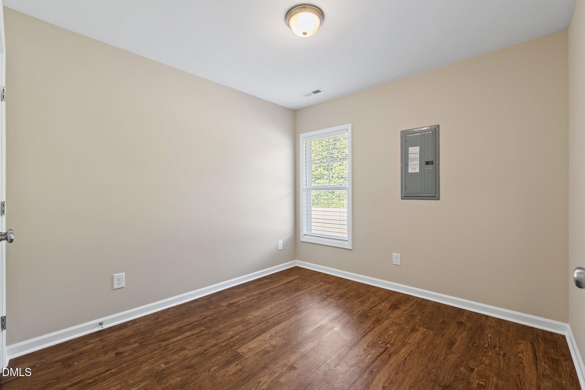 597 Pendergraft Road Bunnlevel, NC 28323 - Photo 12 of 21 an empty room with wooden floor and windows