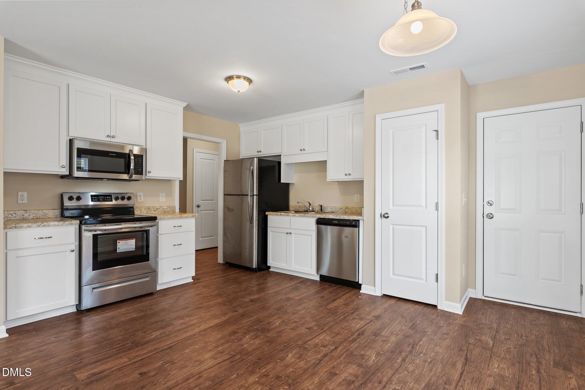 597 Pendergraft Road Bunnlevel, NC 28323 - Photo 5 of 21 a kitchen with granite countertop a refrigerator and a stove top oven