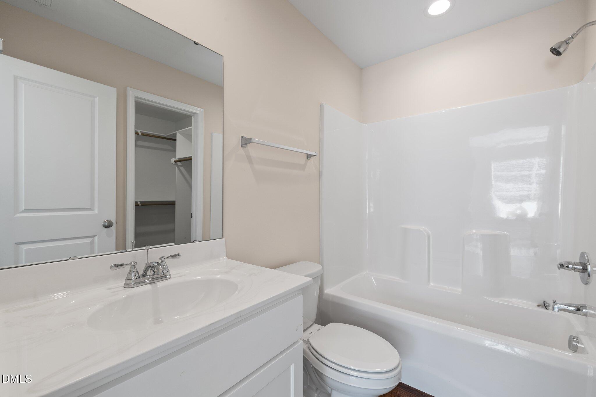 597 Pendergraft Road Bunnlevel, NC 28323 - Photo 10 of 21 a bathroom with a bathtub shower sink vanity mirror and toilet