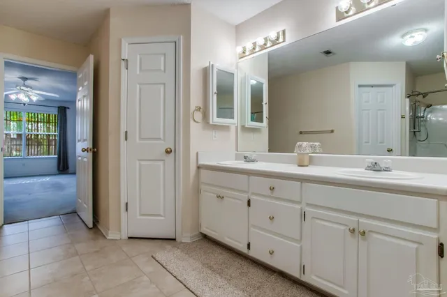 an empty room with a chandelier fan and a bathroom