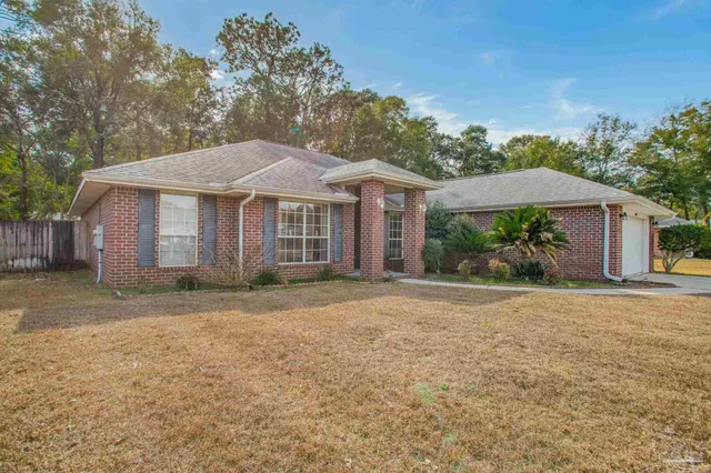 a front view of a house with a yard and trees