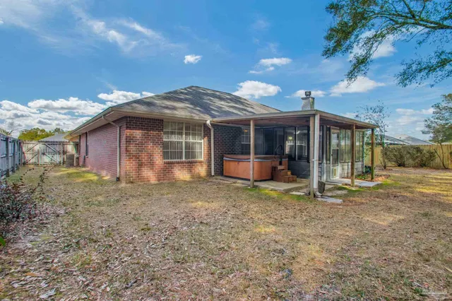 a view of a house with backyard and a tree