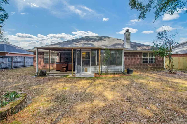 a backyard of a house with large trees and wooden fence