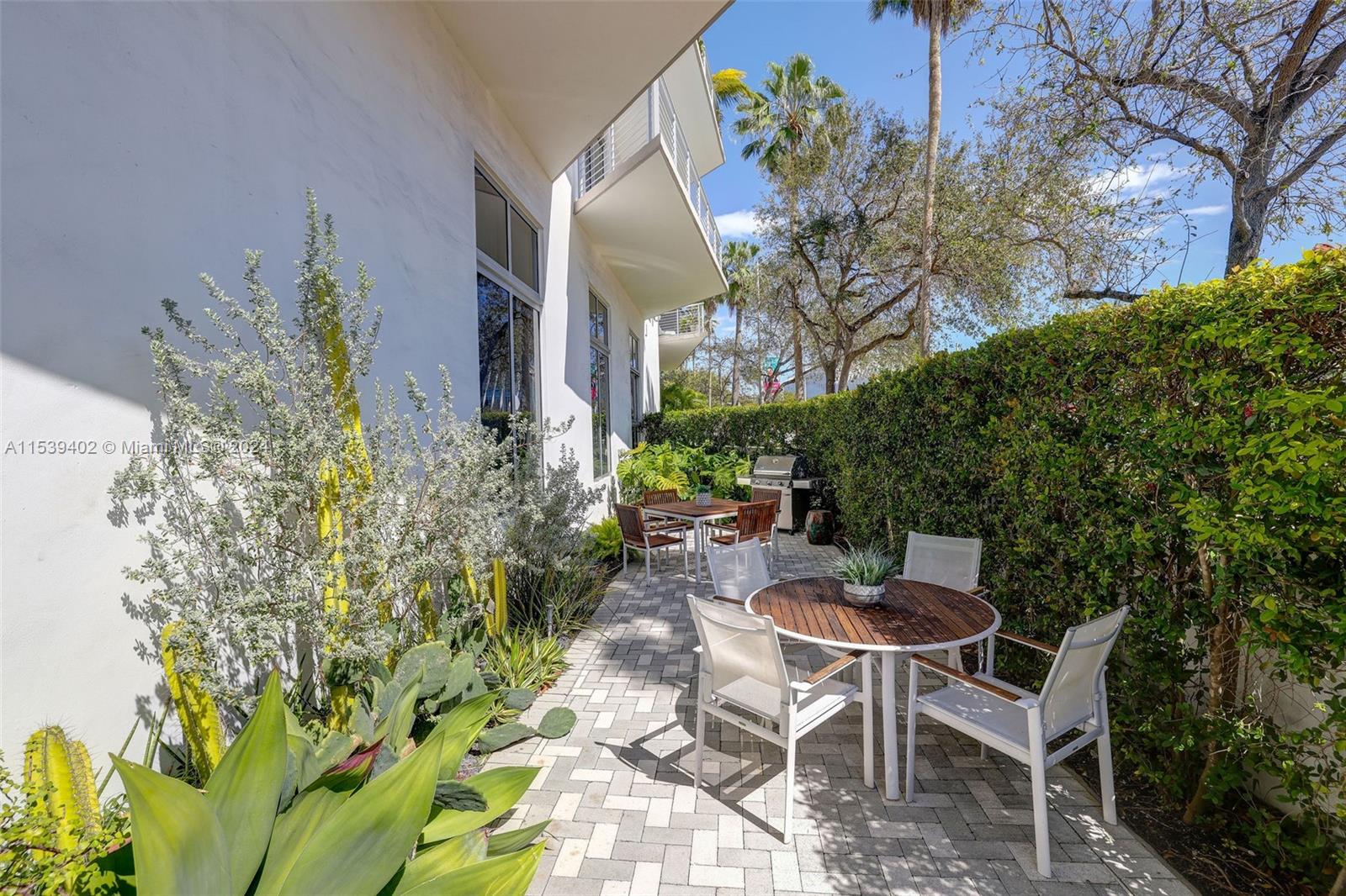 2001 Meridian Avenue, Unit 101 Miami Beach, FL 33139 - Photo 46 of 66 a patio with table and chairs and potted plants