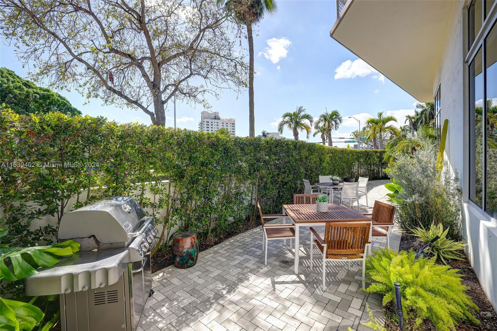 2001 Meridian Avenue, Unit 101 Miami Beach, FL 33139 - Photo 52 of 66 a backyard of a house with table and chairs