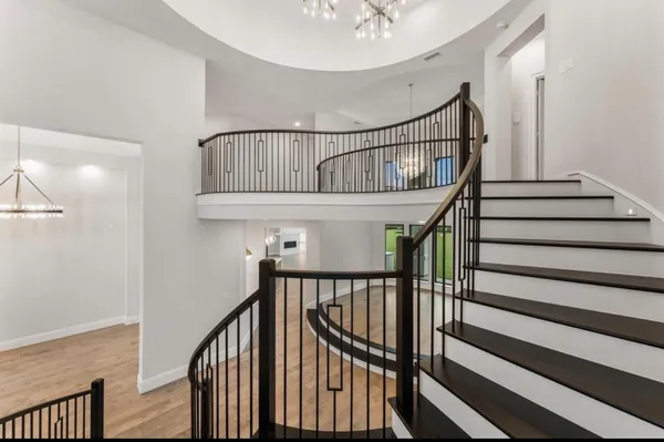 a view of staircase with wooden floor and white walls