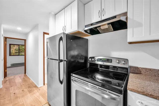 a kitchen with stainless steel appliances granite countertop a refrigerator and a stove