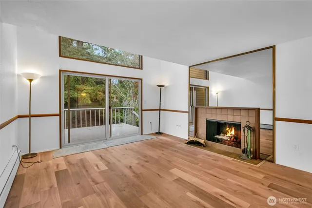 a view of empty room with wooden floor and fireplace
