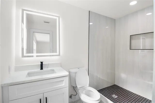 an empty room with wooden floor closet and windows
