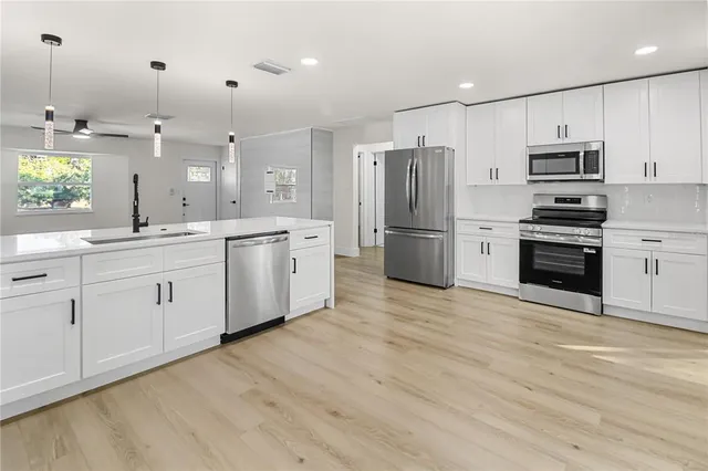 a kitchen with stainless steel appliances a refrigerator sink and cabinets