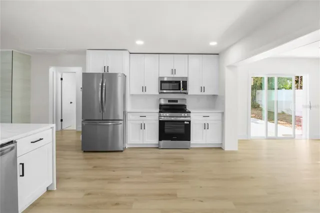 a kitchen with stainless steel appliances a refrigerator sink and cabinets