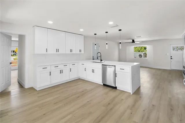 a large white kitchen with wooden floors and white cabinets