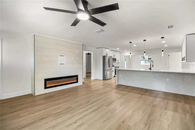 a view of a kitchen with wooden floor and a sink