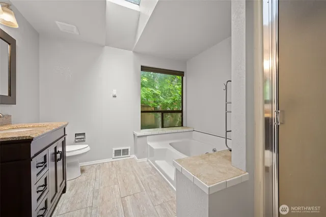 a bathroom with a sink toilet and window