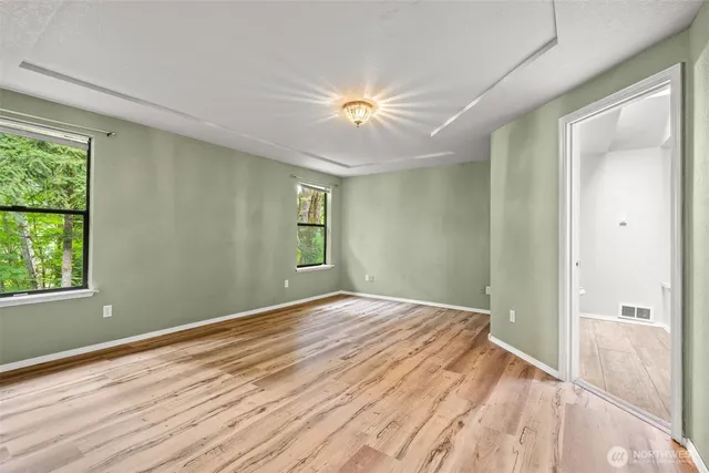 wooden floor in an empty room with a window