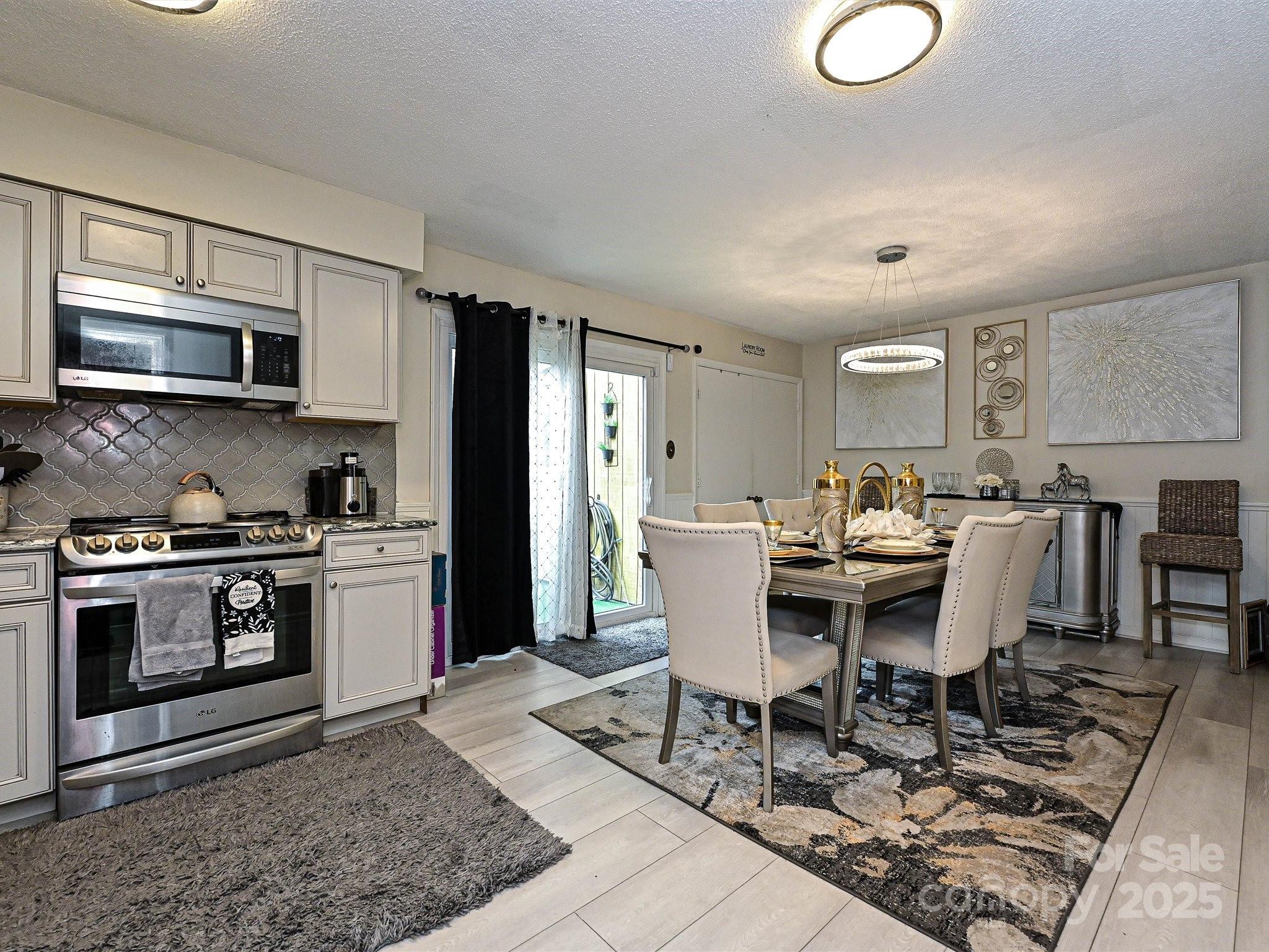 4520 Central Avenue, Unit H Charlotte, NC 28205 - Photo 1 of 28 a living room with stainless steel appliances kitchen island granite countertop a stove a sink a microwave and a dining table