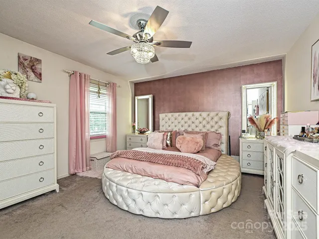 a spacious bedroom with a bed and a chandelier