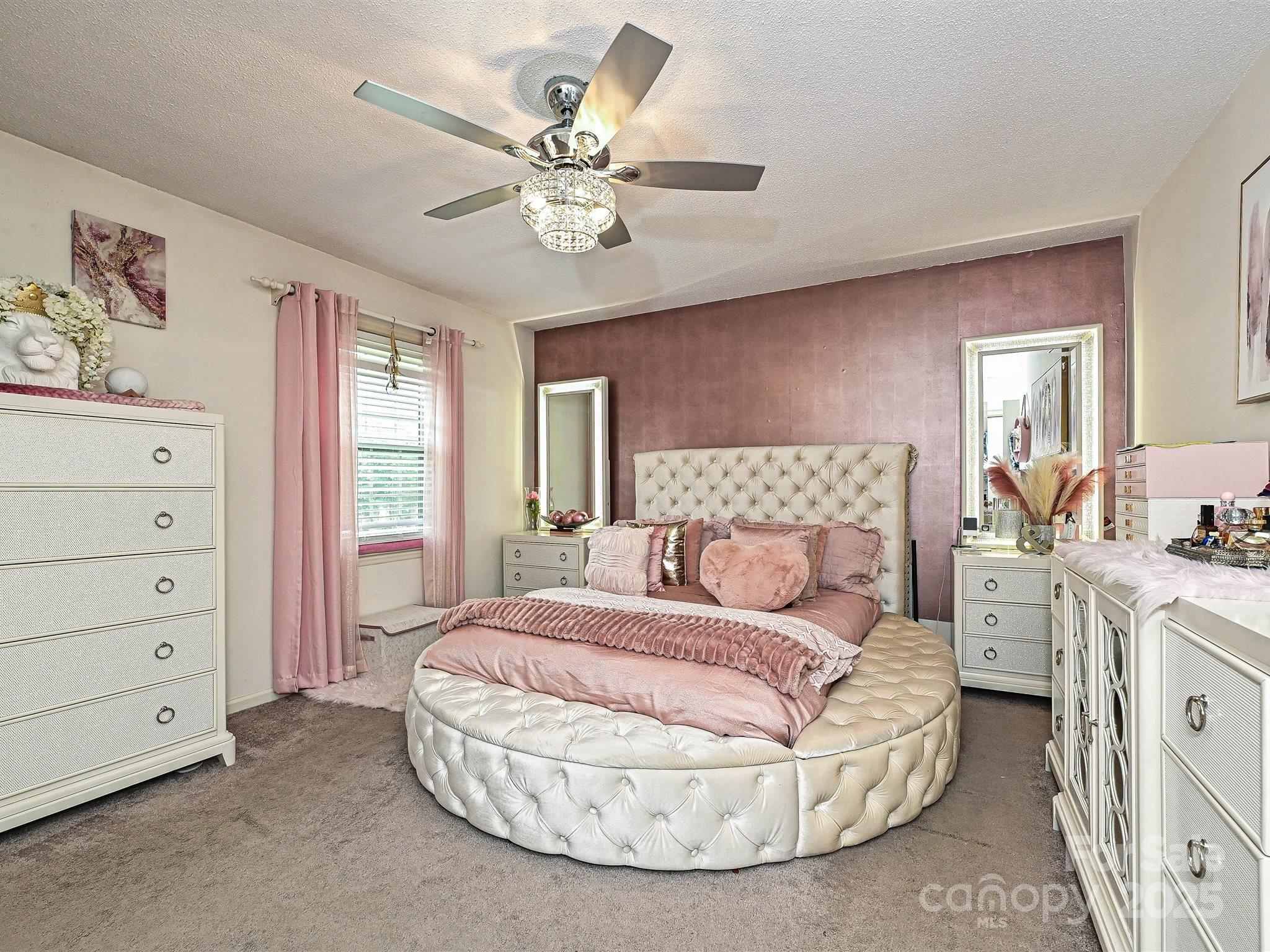 4520 Central Avenue, Unit H Charlotte, NC 28205 - Photo 16 of 28 a spacious bedroom with a bed and a chandelier