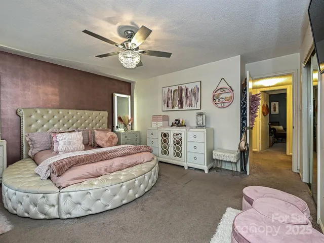 a spacious bedroom with a bed and a chandelier