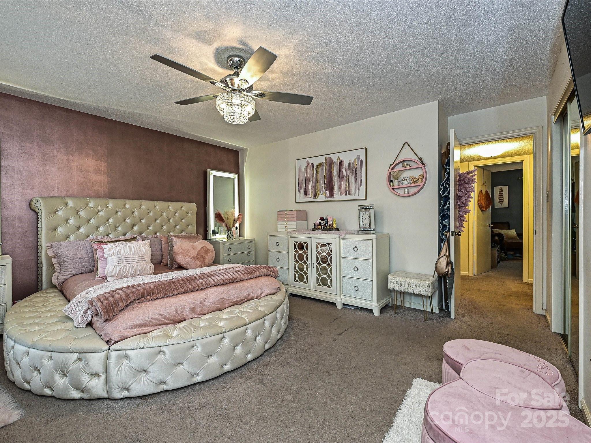 4520 Central Avenue, Unit H Charlotte, NC 28205 - Photo 17 of 28 a spacious bedroom with a bed and a chandelier