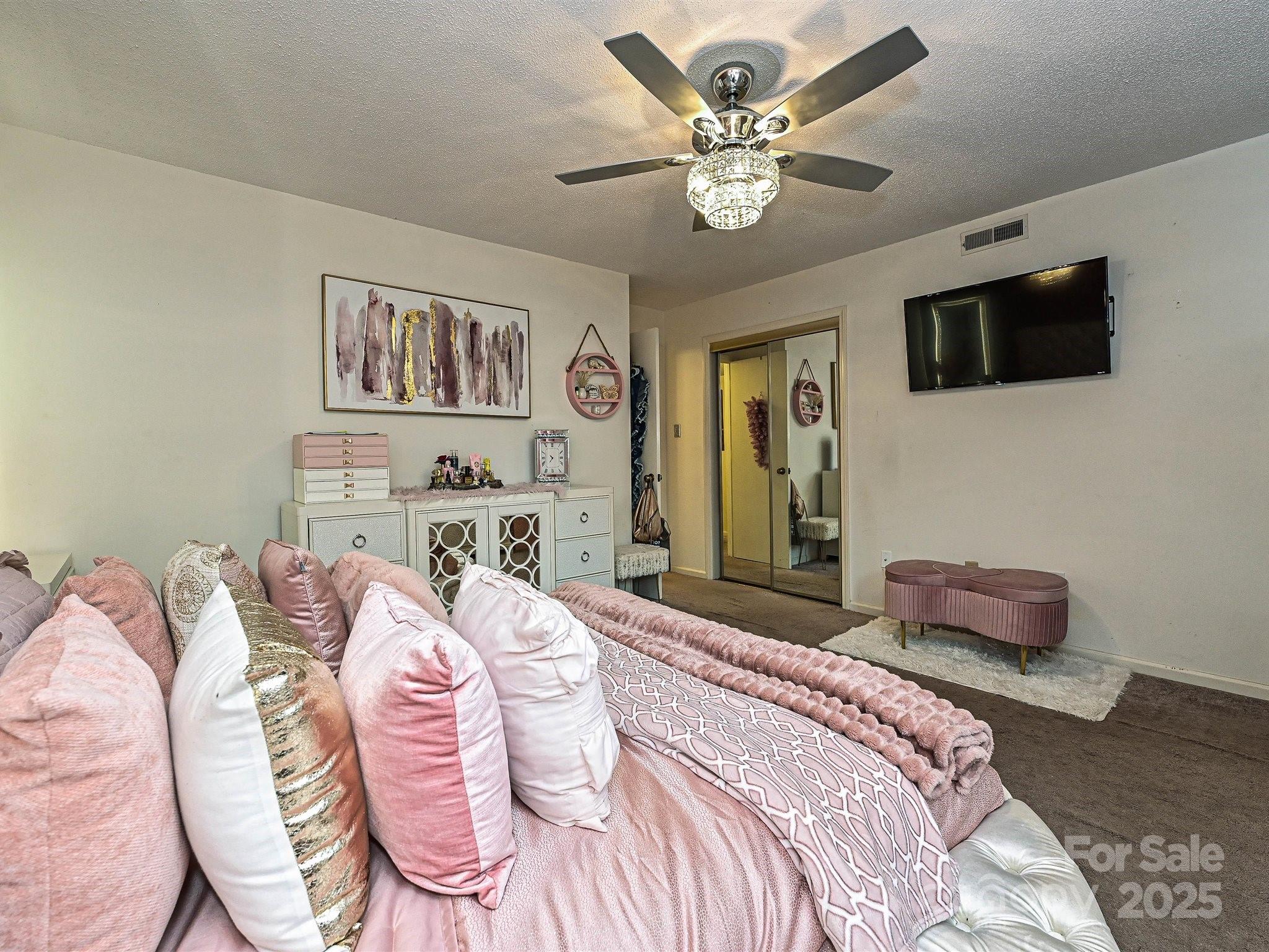 4520 Central Avenue, Unit H Charlotte, NC 28205 - Photo 18 of 28 a bedroom with a bed a chandelier and a couch