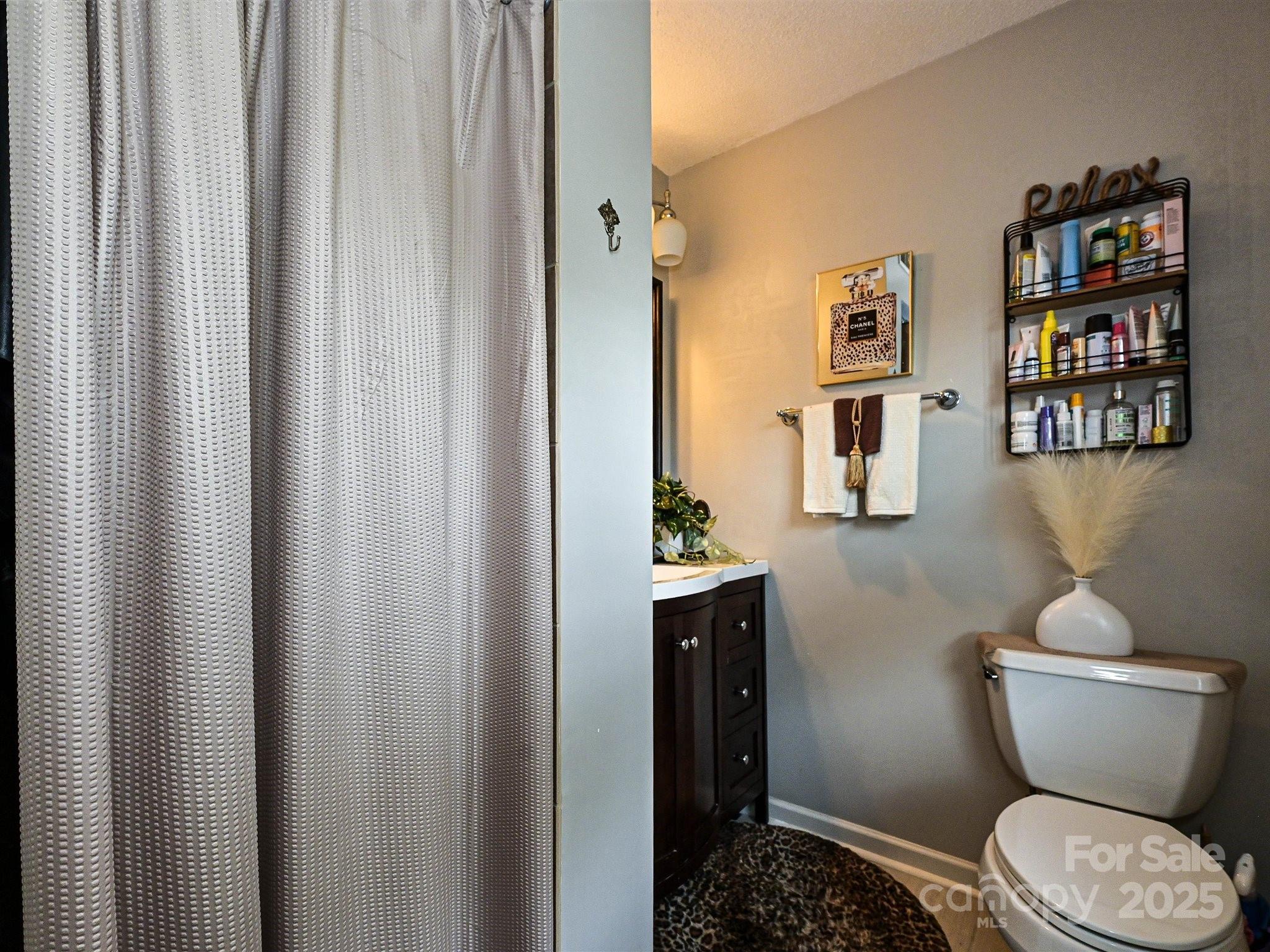 4520 Central Avenue, Unit H Charlotte, NC 28205 - Photo 19 of 28 a bathroom with a toilet and a shower curtain