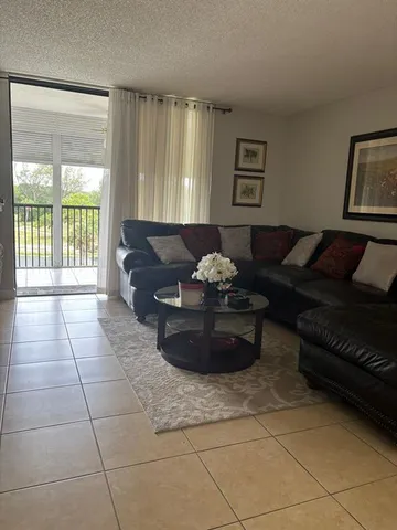 a living room with furniture and a floor to ceiling window
