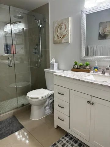 a bathroom with a toilet sink vanity and mirror