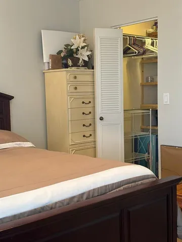 a bedroom with a bed and cabinet