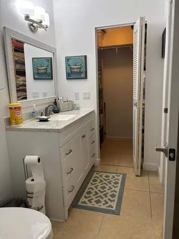 a bathroom with a toilet a sink a mirror a vanity and shower