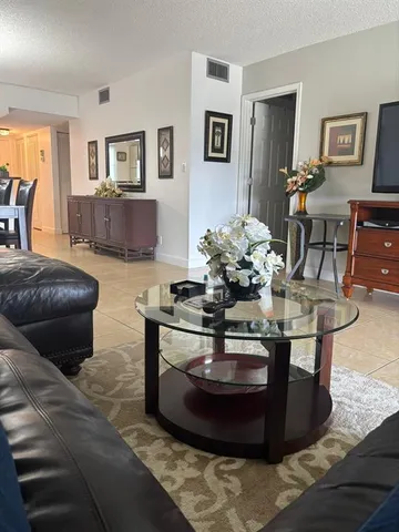 a living room with furniture and chandelier
