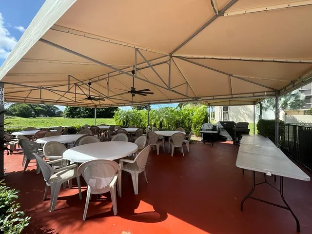 a view of a patio with a table and chairs under an umbrella